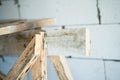 Wooden homemade scaffolding close-up against the background of a bare aerated concrete wall