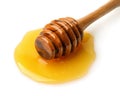 Wooden honey dipper in honey puddle