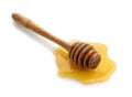 Wooden honey dipper in honey puddle