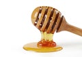 A wooden honey dipper placed on a pool of golden honey with a white background Royalty Free Stock Photo