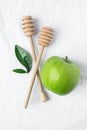Wooden Honey Dippers Ripe Green Apple Leaves on White Cotton Linen Fabric Background. Organic Cosmetics Ayurveda Healthy Lifestyle