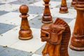 Wooden horse knight chess piece on large outdoor chess board