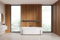 Wooden hotel bathroom interior with washbasin and tub, panoramic window Royalty Free Stock Photo