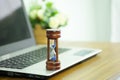 Wooden hourglass on a laptop computer, Managing time