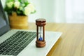 Wooden hourglass on a laptop computer, Managing time