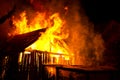 Wooden house or barn burning on fire at night Royalty Free Stock Photo