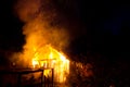 Wooden house or barn burning on fire at night Royalty Free Stock Photo