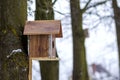 A wooden house for birds on the tree in the forest. Place to feed and to find food in winter time for birds. Bird feeder in park. Royalty Free Stock Photo