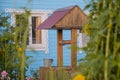 Wooden house with blue facade and white frames on the windows and old wooden well Royalty Free Stock Photo