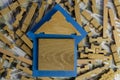 A wooden house on a blue lining on top of a wooden puzzle and money