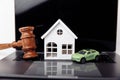 Wooden house, car and judge gavel. Purchase, sale of real estate Royalty Free Stock Photo