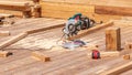 Wooden house construction site with fresh wood planks and miter saw