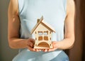 Wooden house in female hands as a symbol. Stay home to reduce the risk of infection and spread of the virus Royalty Free Stock Photo