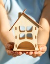 Wooden house in female hands as a symbol. Stay home to reduce the risk of infection and spread of the virus Royalty Free Stock Photo