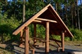 wooden house by the forest on a meadow for tourists. it has an a-shaped roof.