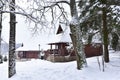 Wooden house in forest in winter time. Log cabin in the forest alone in wilderness. Wooden houses with a wooden roof against Royalty Free Stock Photo