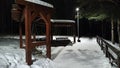 Wooden house, gazebo in a dark snowy forest at night Royalty Free Stock Photo