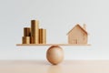 Wooden house and golden coin on balancing scale on white background. Real estate business mortgage investment and financial loan Royalty Free Stock Photo