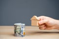 Wooden house in hands and money dollar bills. The concept of attracting investment in real estate. Mortgages and home loans. Royalty Free Stock Photo