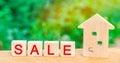 Wooden house with the inscription `sale`. sale of property, home, real estate. affordable housing.