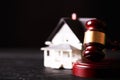 Wooden judge gavel and house on dark background Royalty Free Stock Photo