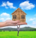 Wooden house with key in hand Royalty Free Stock Photo