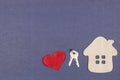 Wooden house, keys and a red heart on a gray-blue background. The concept of love, happiness in your home Royalty Free Stock Photo