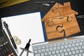 Wooden House made of Jigsaw Puzzle Pieces on a Desk Royalty Free Stock Photo