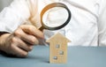 Wooden house and magnifying glass. Property valuation. Choice of location for the construction. House searching concept. Search Royalty Free Stock Photo