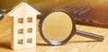 Wooden house and magnifying glass. Property valuation. Choice of location for the construction. House searching concept. Search Royalty Free Stock Photo