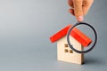 Wooden house and magnifying glass. Property valuation. Home appraisal. Choice of location for the construction. House searching