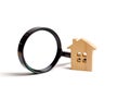 Wooden house and magnifying glass on a white background. Buying and selling real estate, building new buildings, offices and homes Royalty Free Stock Photo