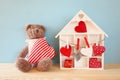 Wooden house with many hearts and cute teddy bear Royalty Free Stock Photo