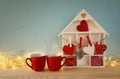 Wooden house with many hearts next to coffee cups Royalty Free Stock Photo