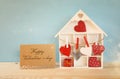 Wooden house with many hearts next to letter on the table Royalty Free Stock Photo