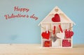 Wooden house with many hearts on the table Royalty Free Stock Photo