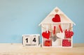 Wooden house with many hearts on the table Royalty Free Stock Photo