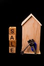 wooden house mockup with house keys, wooden cubes with words rent sale , buy and loan. on black background