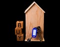 wooden house mockup with house keys, wooden cubes with words rent sale , buy and loan. on black background