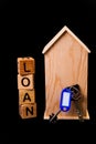 wooden house mockup with house keys, wooden cubes with words rent sale , buy and loan. on black background