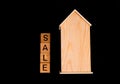 wooden house mockup with house keys, wooden cubes with words rent sale , buy and loan. on black background