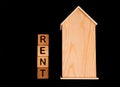 wooden house mockup with house keys, wooden cubes with words rent sale , buy and loan. on black background