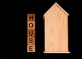 wooden house mockup with house keys, wooden cubes with words rent sale , buy and loan. on black background