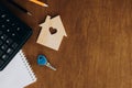 Wooden house model, calculator and key on a wooden table, flat lay. Royalty Free Stock Photo