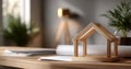 Wooden house model on desk with architectural plans and blurred background in modern workspace Royalty Free Stock Photo