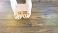 A wooden house model in the hands of a child on a wooden background. Royalty Free Stock Photo