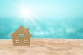 Wooden house model on sand beach with seascape view in background. Royalty Free Stock Photo