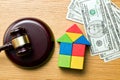Wooden house with money and judge gavel Royalty Free Stock Photo