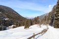 Wooden house, mountain panorama, trees and path with snow in winter in Stubai Alps