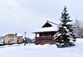 Wooden house in mountain in winter time. Log cabin in forest alone in wilderness. Wooden house with a wooden roof against Royalty Free Stock Photo